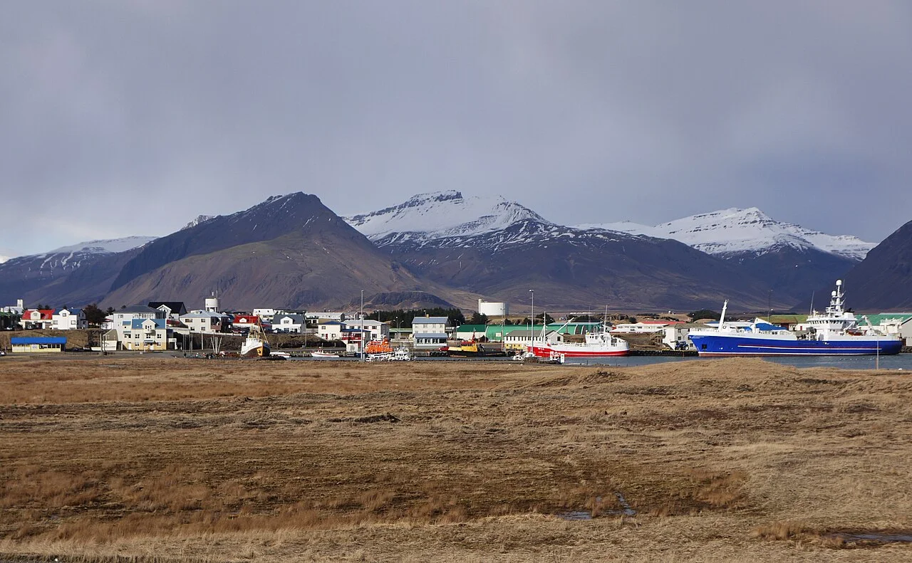 Höfn harbour with fishing boats, town buildings and mountains behind