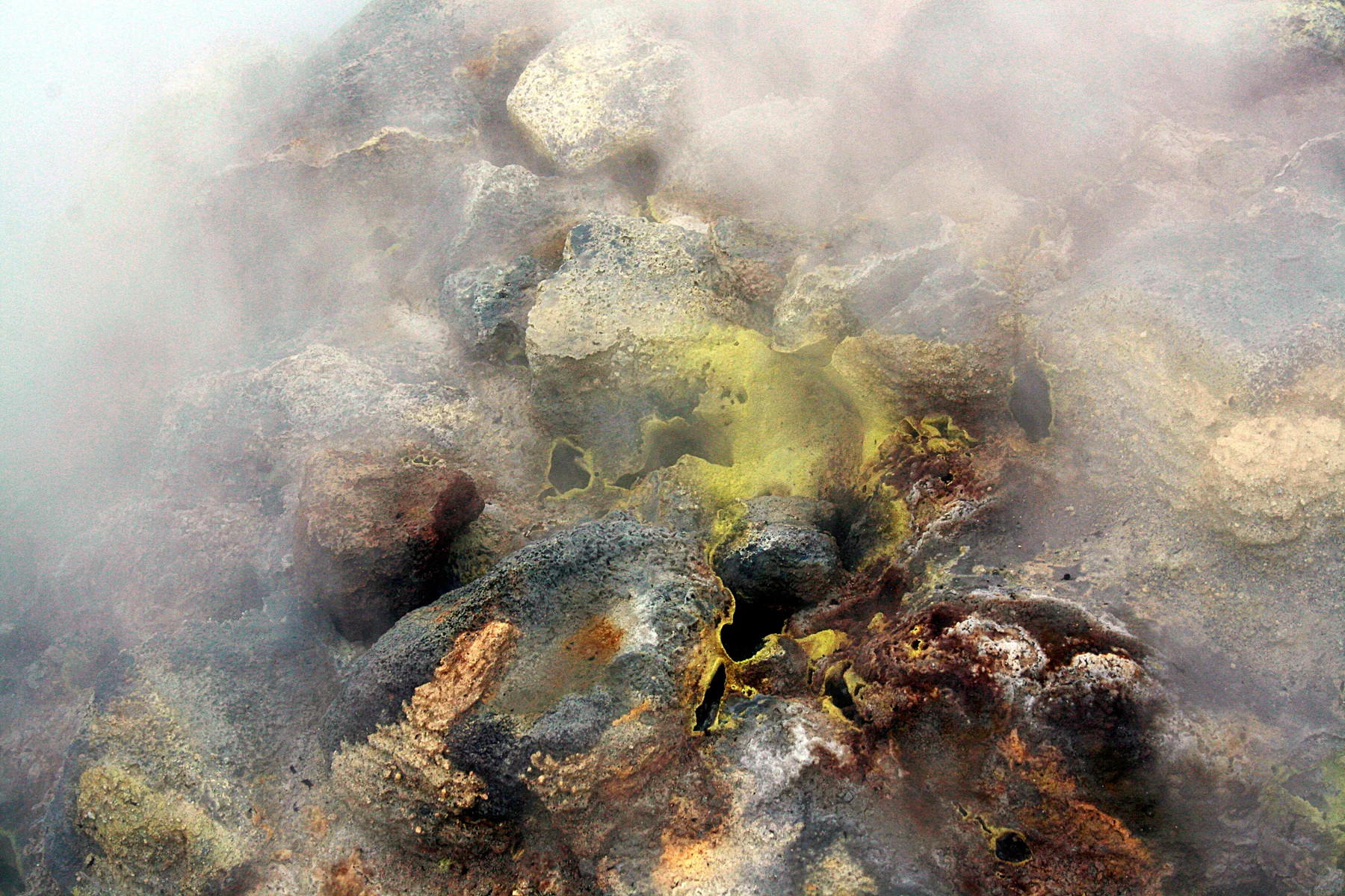 Steam, sulfur deposits, and rocks in the Hverir geothermal area
