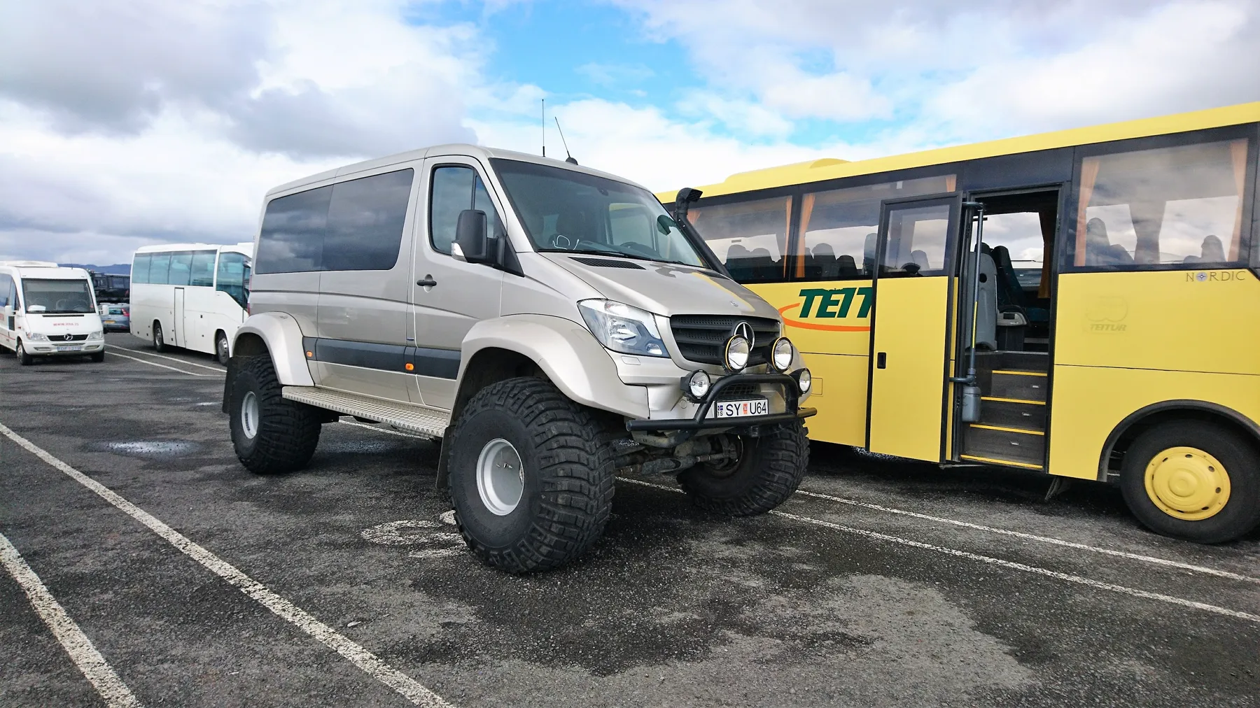 A converted Mercedes-Benz Sprinter and a bus at an Iceland vehicle collection area