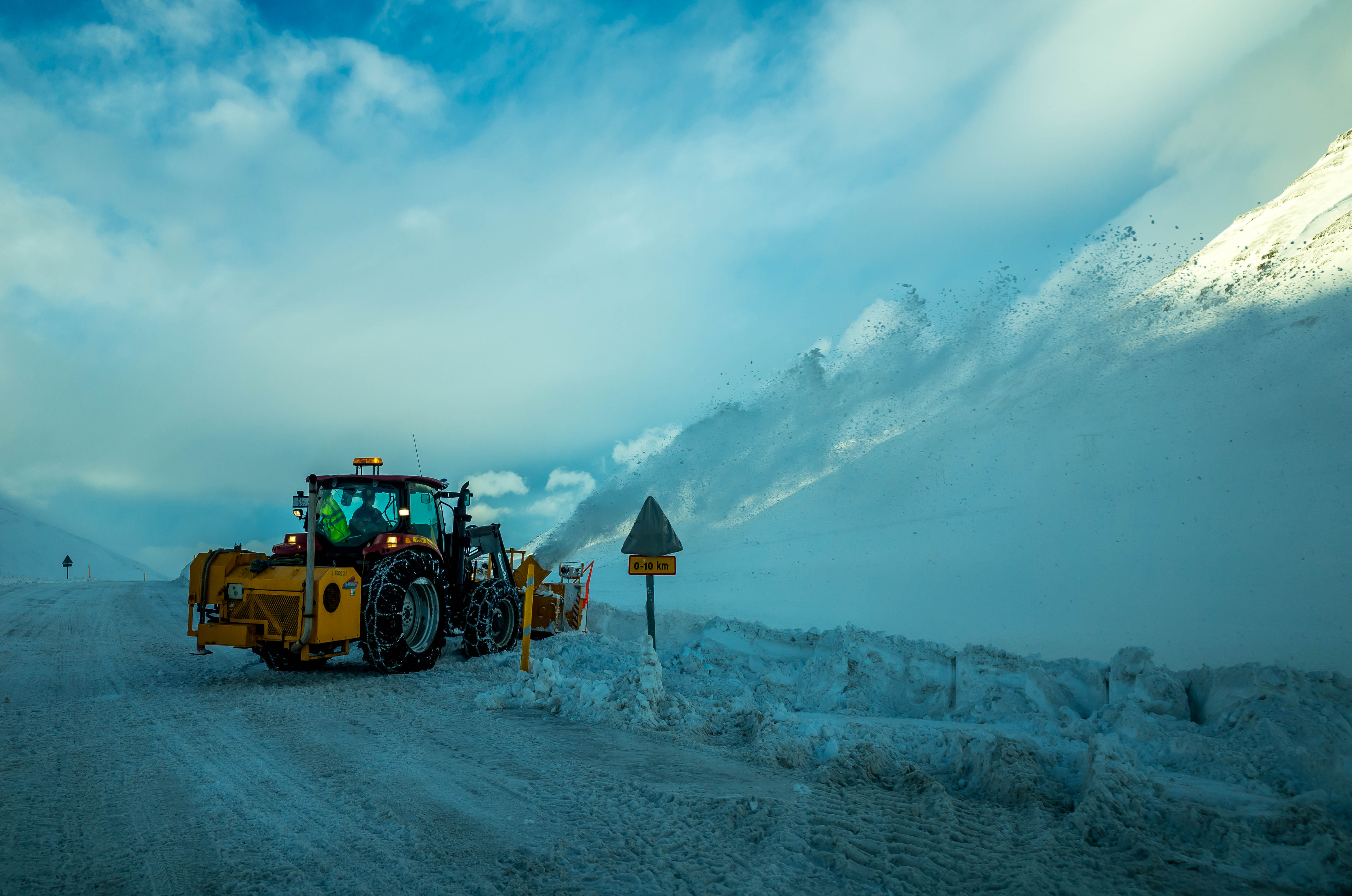 A snowplough clearing Iceland's Route 1 in winter beside a warning sign; the photograph shows winter road maintenance and scale, not a 4WD requirement or current road conditions