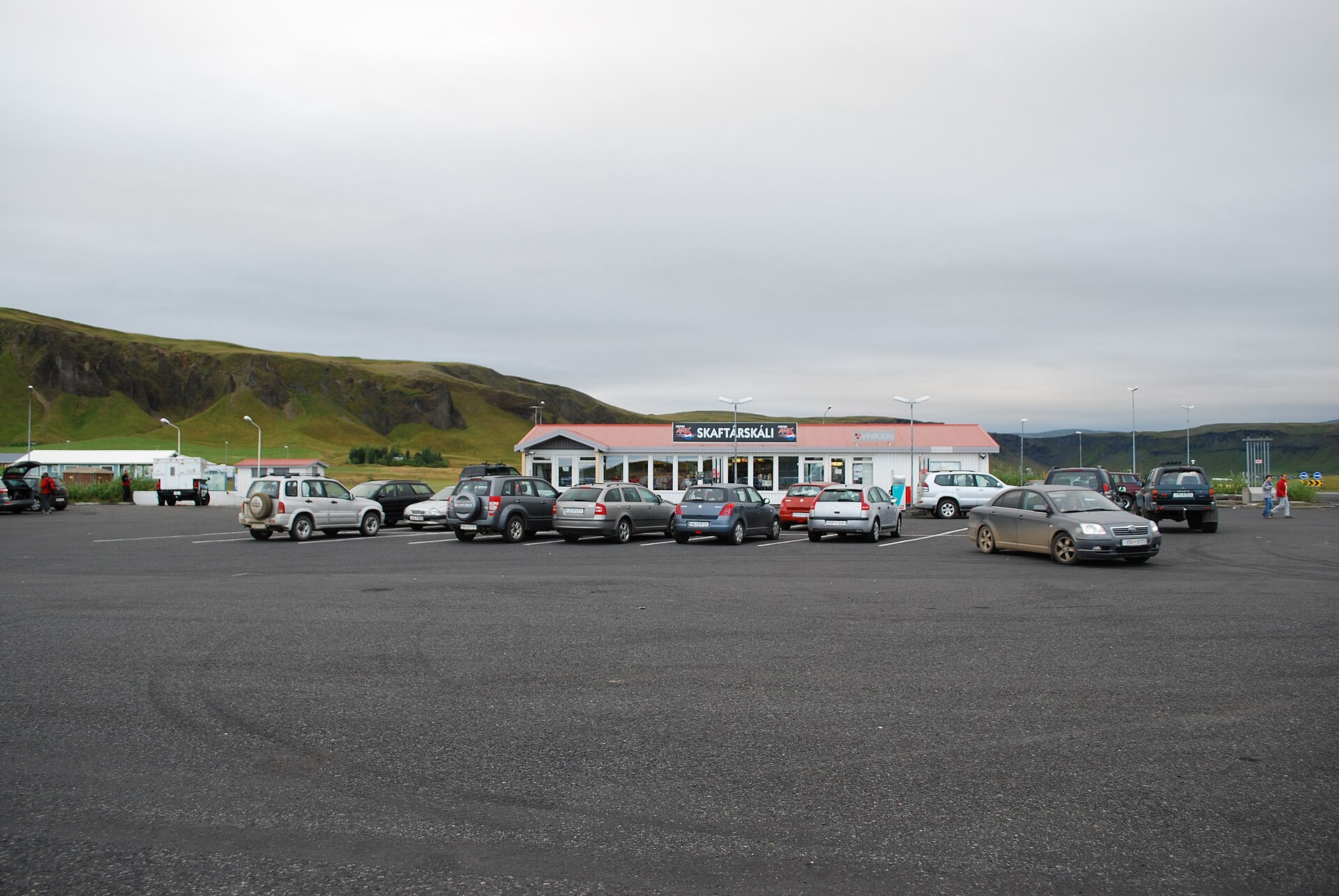 A roadside petrol station and car park in Kirkjubæjarklaustur, Iceland; the photograph shows the setting of a refuelling stop and does not indicate current opening hours or fuel prices