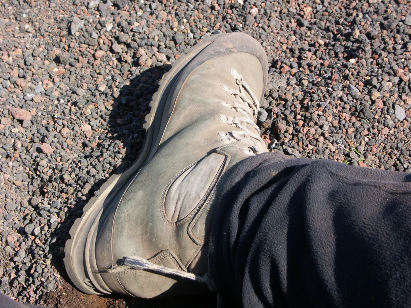 A hiking boot on Icelandic volcanic tephra, showing sole grip rather than guaranteeing suitability for any activity