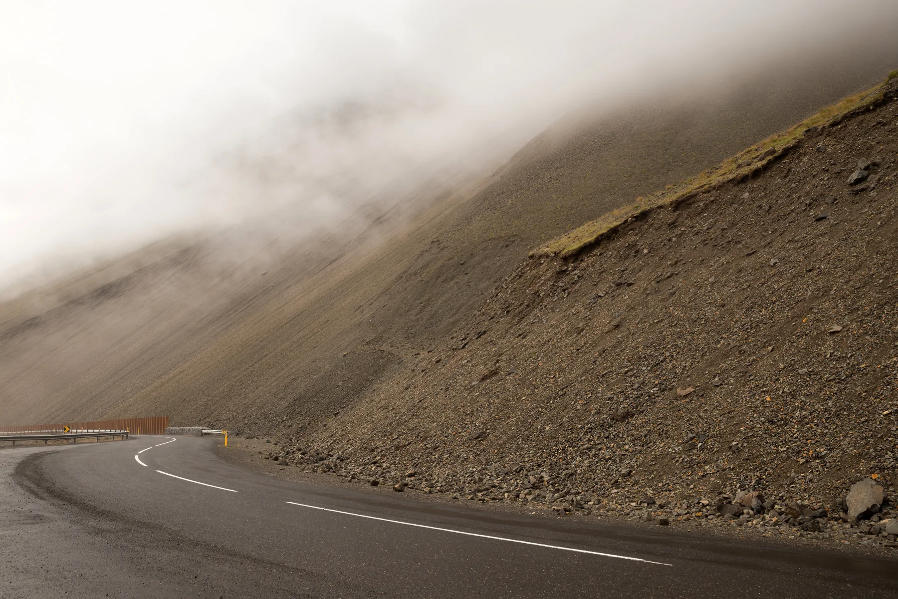 Iceland's Route 1 bends along an East Iceland hillside without a continuous shoulder
